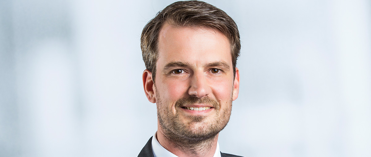 Ein Mann mittleren Alters posiert für die Kamera. Es ist das Gesicht und der Hemdkragen zu erkennen.